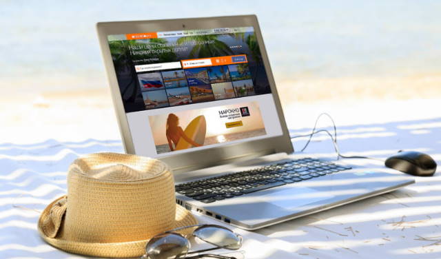 шляпка и очки лежат на пляже возле ноутбука с открытой страницей сайта турагенства с выделенным сервером 